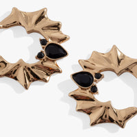 Gold bat-shaped earrings with black gemstones on a white background