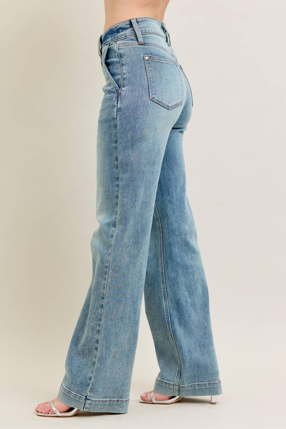 Light blue jeans worn by a person on a plain background