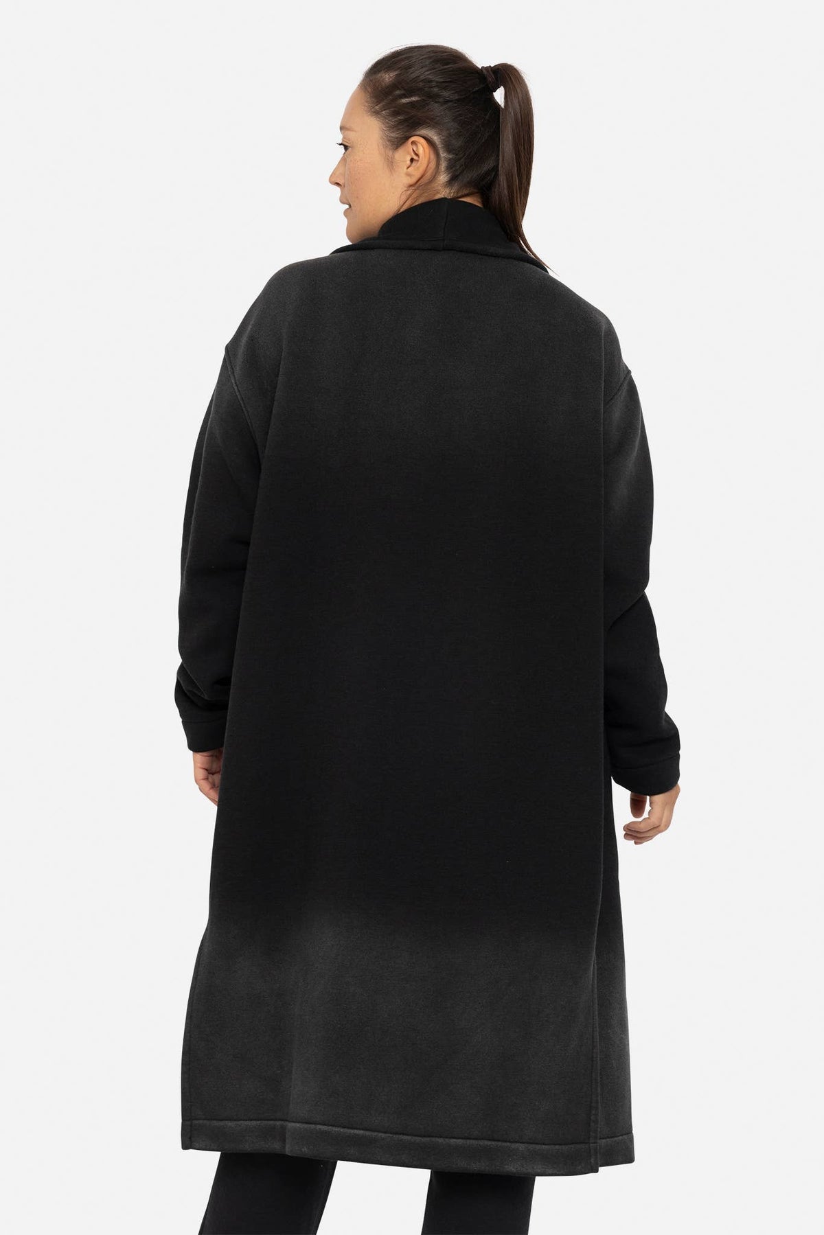 Person wearing a black coat on a white background