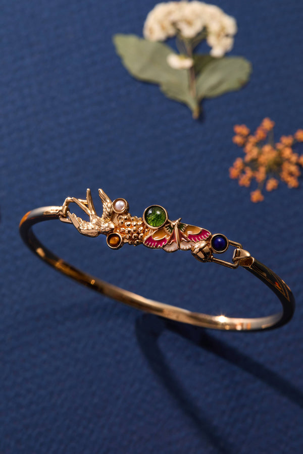 Decorative gold bracelet with gemstones on a blue background