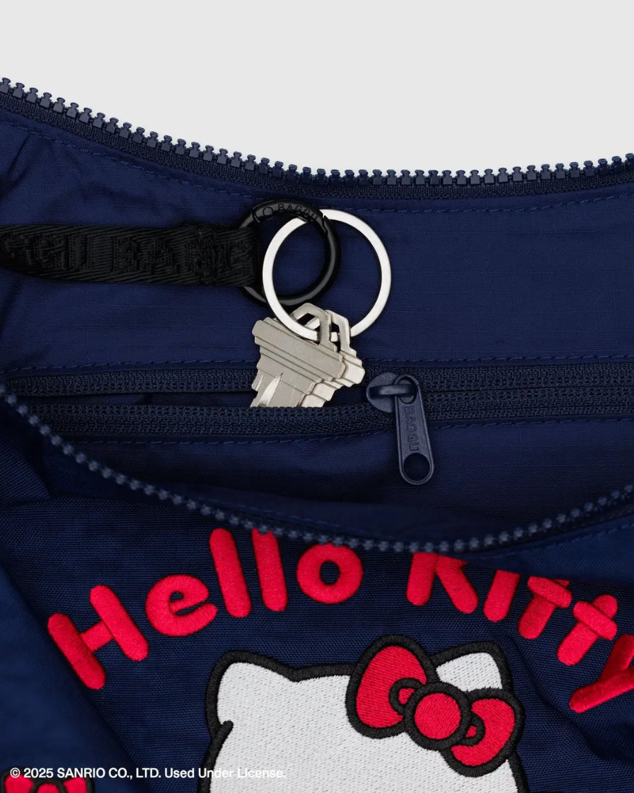 Navy blue bag with 'Hello Kitty' branding and a keychain on a white background