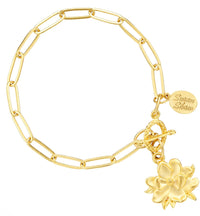 Gold bracelet with a flower charm on a white background