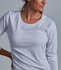 Woman wearing a light gray long-sleeve shirt against a plain background