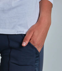 Person wearing navy pants with a visible brand logo on a plain background
