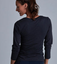 Person wearing a black long-sleeve shirt against a gray background