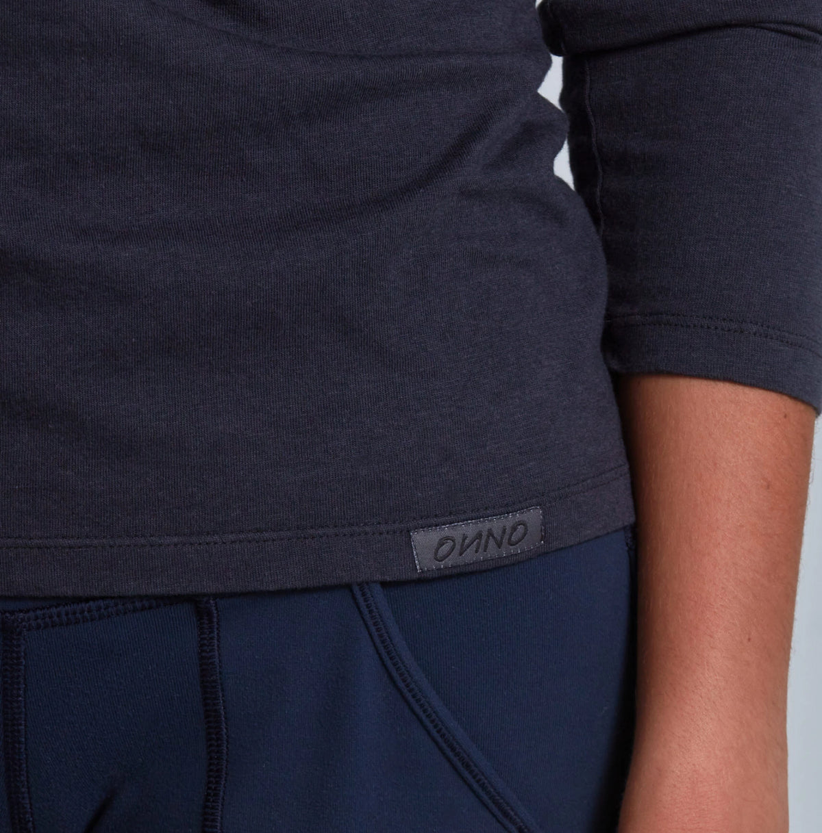 Navy blue athletic outfit with a brand logo on a neutral background