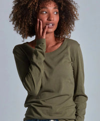 Woman wearing a green long-sleeve shirt against a plain background