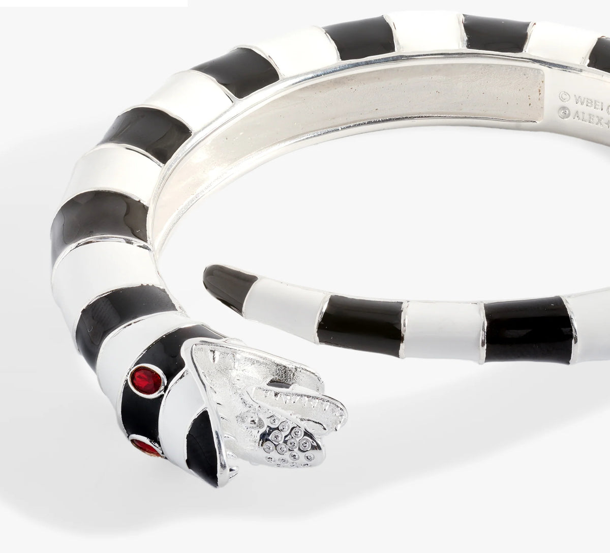 Silver ring with black and white striped design and red gemstone on a white background