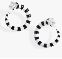 Black and white striped hoop earrings on a white background