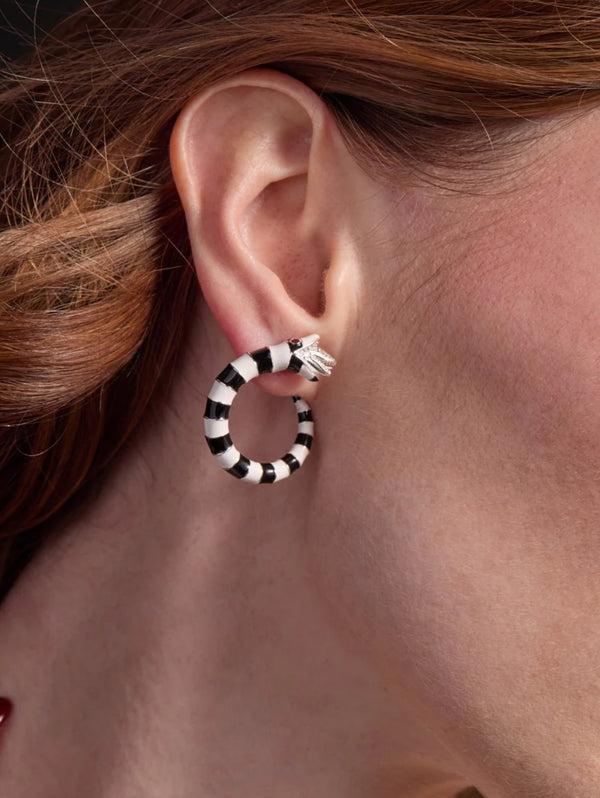 Close-up of an ear wearing a black and white striped hoop earring.