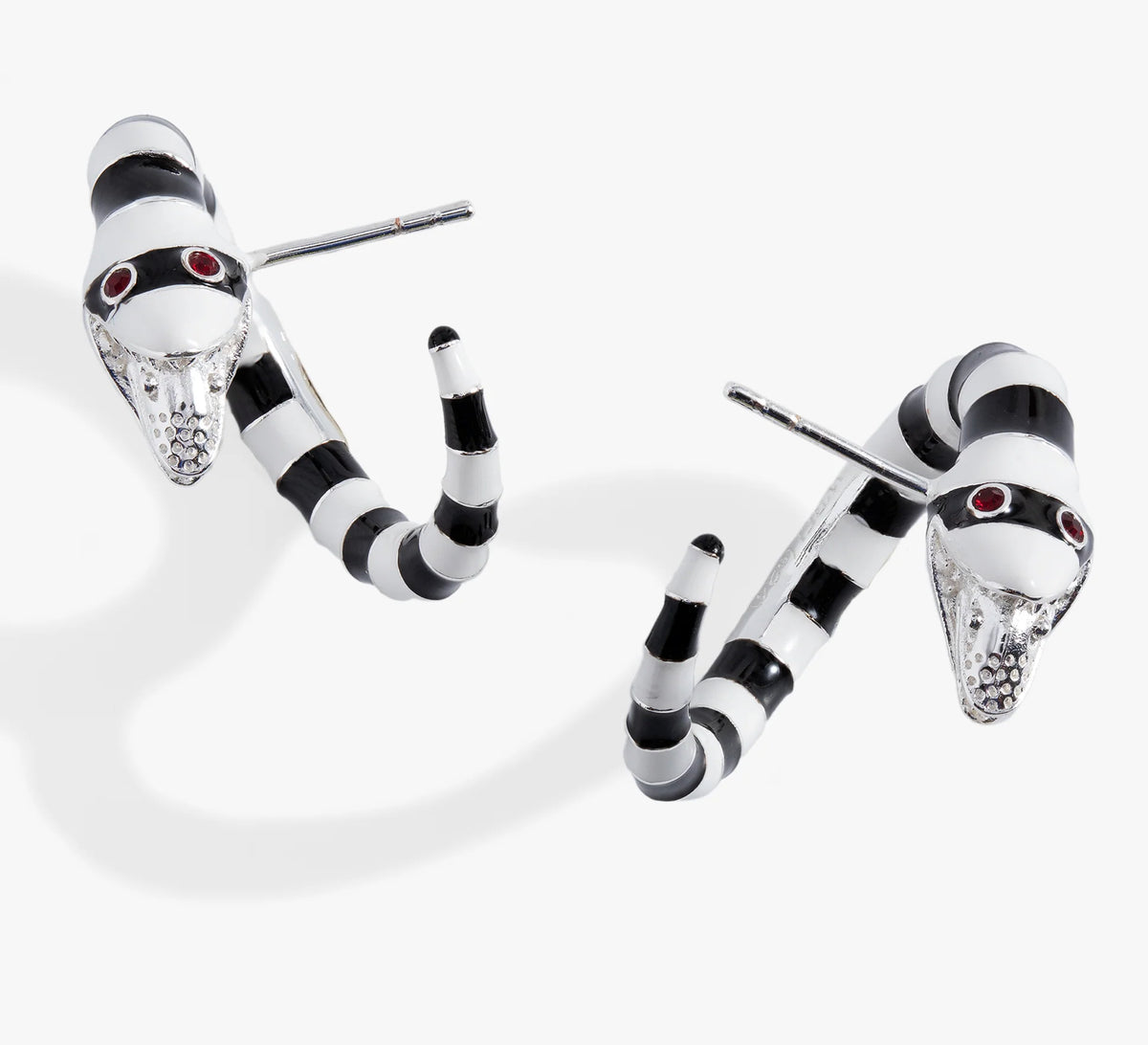 Black and white striped earrings with red gemstones on a white background