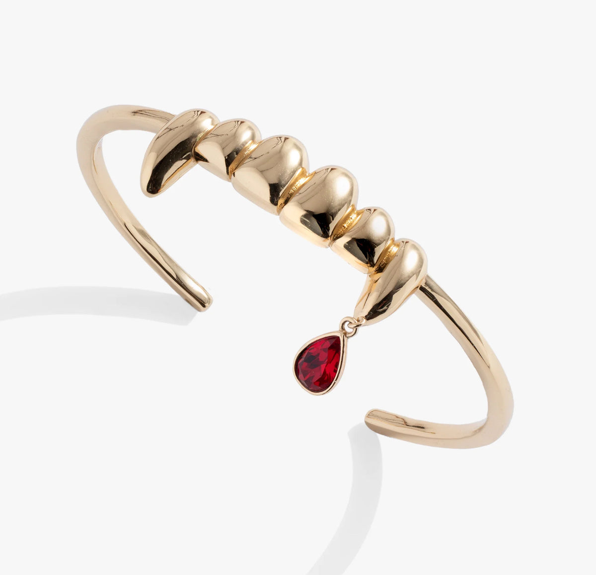 Gold bracelet with a red teardrop charm on a white background