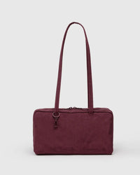 Maroon handbag with a strap on a white background