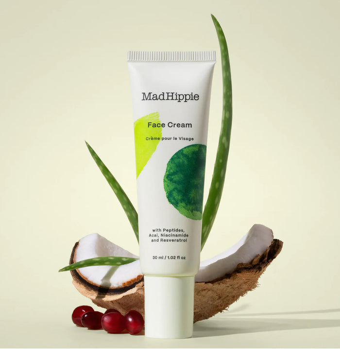 Mad Hippie Face Cream tube with aloe vera leaves and a coconut on a light background