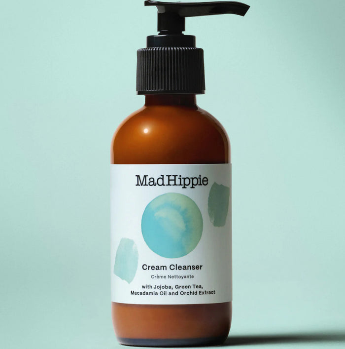 Brown bottle of Mad Hippie Cream Cleanser on a light blue background