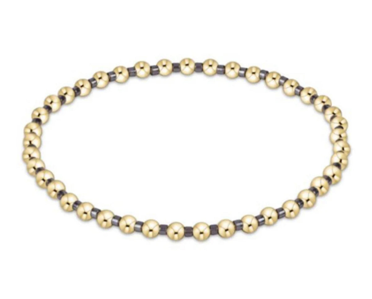 Gold and black beaded bracelet on a white background