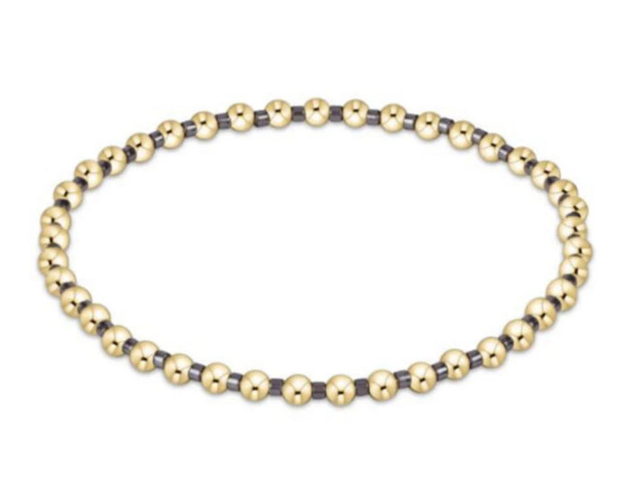 Gold and black beaded bracelet on a white background