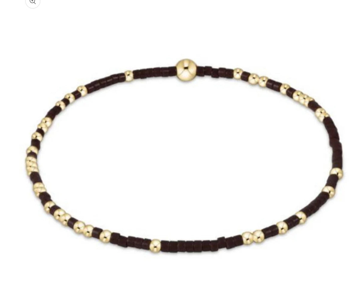 Necklace with brown cord and gold beads on a white background