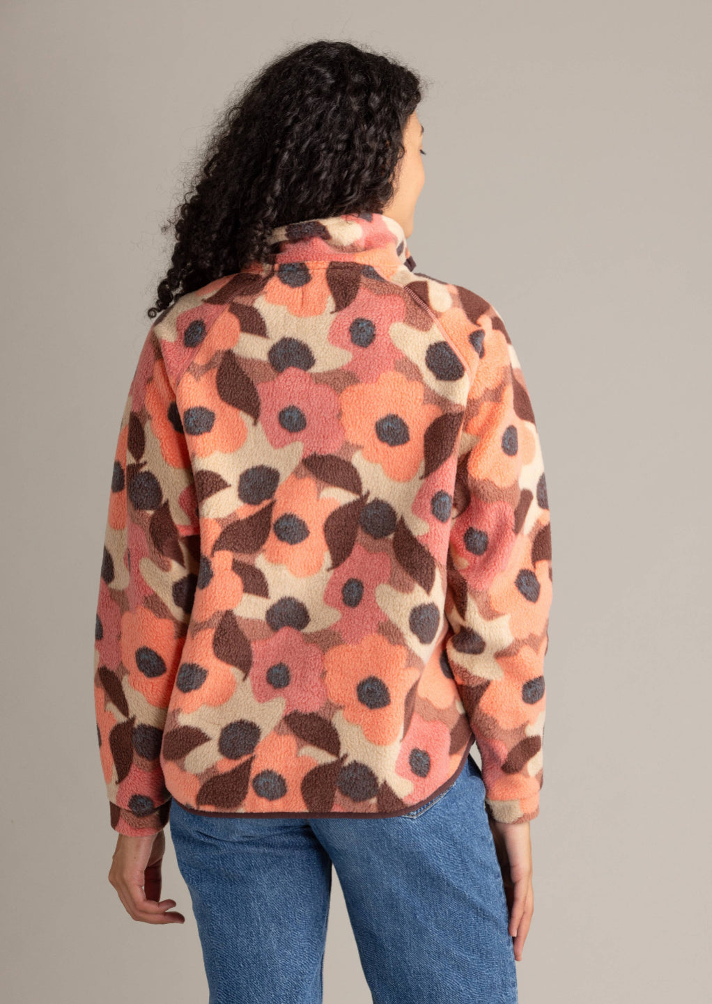 Person wearing a floral patterned shirt with a neutral background