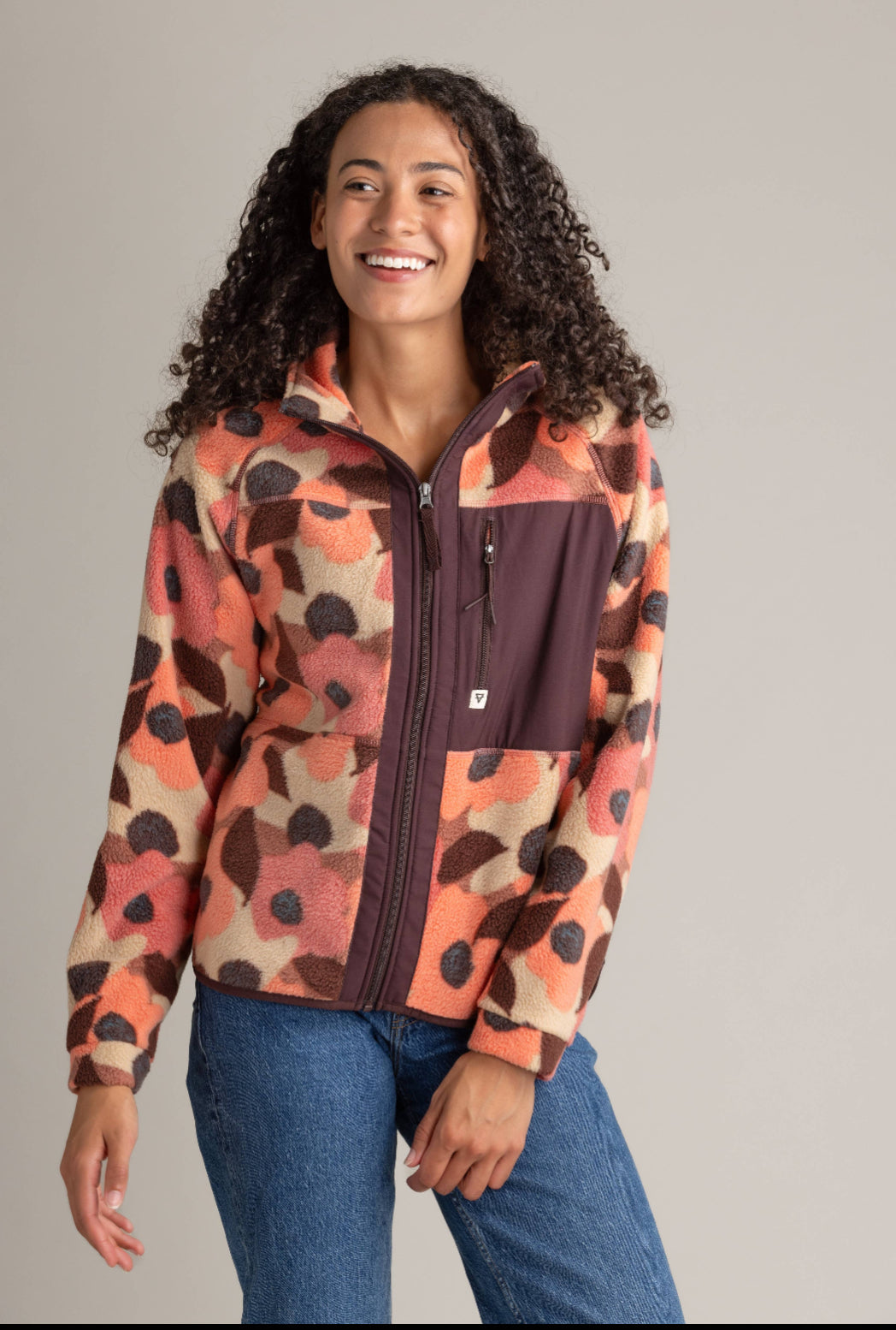 Woman wearing a patterned jacket with a neutral background