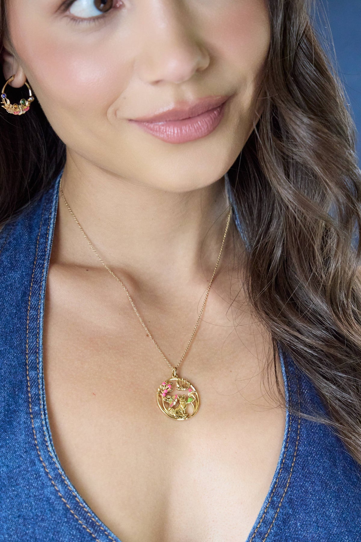 Close-up of a woman wearing a gold necklace with a circular pendant.