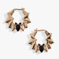 Gold hoop earrings with black heart-shaped stones on a white background